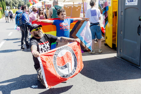 Haifa, Israel June 21, 2024, Pride. A man holds a poster with an anti-fascist flag, a boy of ten is wrapped in a rainbow flag. Father and son.のeditorial素材