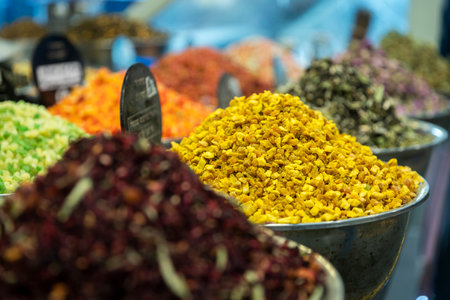 Candied fruits for tea sold at a market - mango, lemon, ginger. Piled up in bowls.
