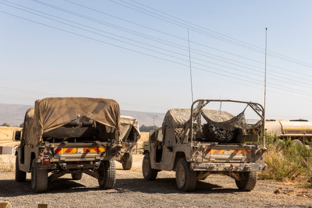 Two Israeli military jeeps in the desert with camouflage nets over their cargo.の写真素材
