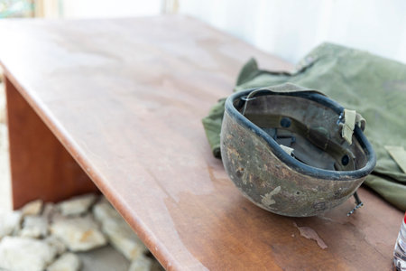 A military helmet covered in dust resting on a table.