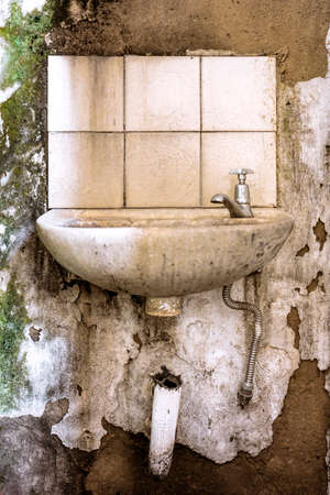 Photo of old, damaged and dilapidated bathroom sink with moldの写真素材