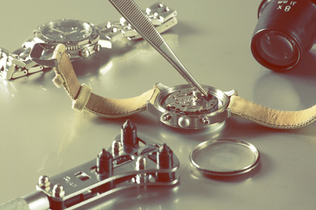 macro of replacing a watch battery with watchmaker toolsの写真素材