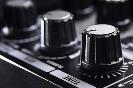 selective focus on the tone knob of an amplifier for electric musical instruments