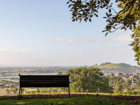 Empty park bench on a hill looking out over the horizonの写真素材