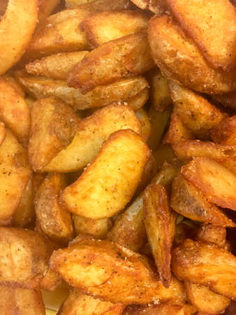 close up view of crispy golden fried potato wedges