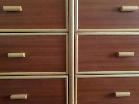 Partial close up view of a yellow bordered cabinet of drawersの写真素材