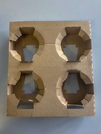 Overhead close up image of a cardboard coffee glass holder for four mugs