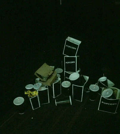 Empty pop corn and drinks cartons piled up against a dark backgroundの写真素材