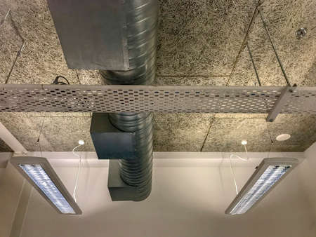 Upward view of an air condition duct and tube lights in an open ceiling planの写真素材