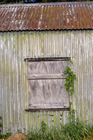 Boarded up window of old rusty shed left abandonedの写真素材
