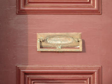 Door knocker and letter box slit on a brown door - close up viewの写真素材