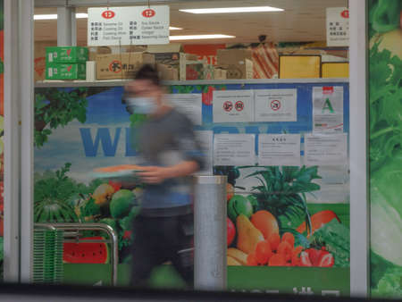 Man wearing a mask exiting an Asian Supermarket in Auckland during the pandemic lock downの写真素材