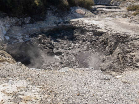 Hot smoke billowing out of a geo thermal valley on a warm sunny day in Rotorua New Zealandの写真素材