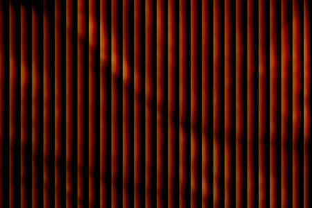 This image showcases a visually striking pattern of evenly spaced sticks in warm tones like yellow, orange, red, and purple, arranged vertically. The composition emphasizes color harmony, symmetry, and texture.の写真素材