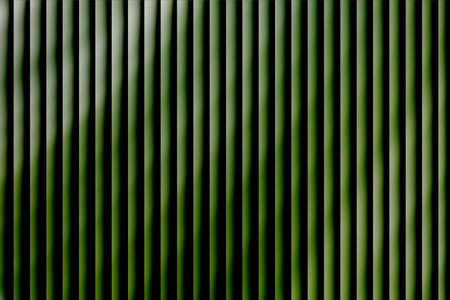 A striking image showcasing a series of bright green vertical lines with varying shades, creating a vivid and energetic pattern. Perfect for modern design, backgrounds, or artistic projects emphasizing bold geometry and vibrant color.の写真素材