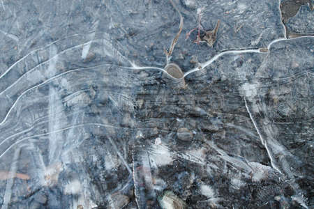 Pebbles can be seen through the crust of ice. Under the first crust of ice on a puddle, pebbles are...
