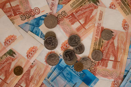 Russia, Barnaul, December 26, 2021: Monetary background. Background of rubles. The banknotes on top are coins. There are coins on the banknotes. Money, rubles. Russian money.のeditorial素材