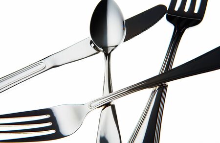 view of nice chromed utensils interlacing on white sheet