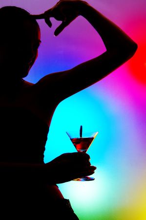 silhouette of dancing girl with martini glass on colorful back.の写真素材