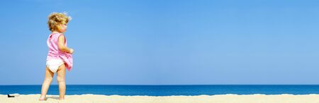 Portrait of blond blue eyed  having fun on the beach. Banner lots of copy spaceの写真素材