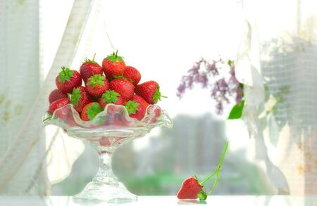 High key photo of fruit dish filled with nice red strawberries  の写真素材