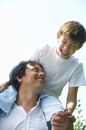 Portrait of young happy father getting  busy with his son