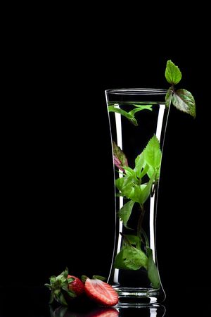 View of long glass filled with fresh drink on black backの写真素材
