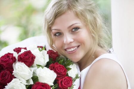high key portrait of beautiful young woman with rose bouquet の写真素材