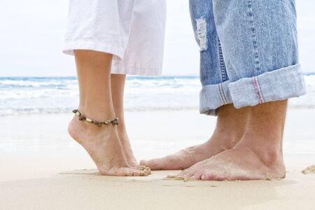 Close up view of  pair of humanâs feet on sandy beach backの写真素材