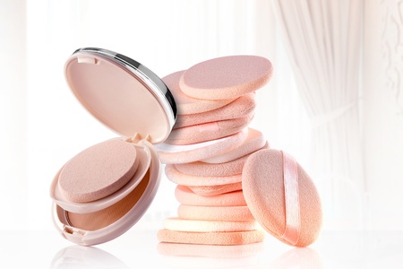 Close up view of  powder and cosmetic sponges on color  backの写真素材