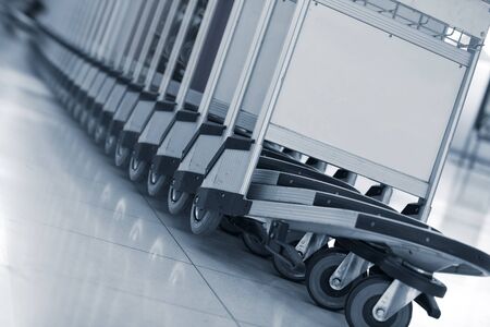 Close up view of trolleys  luggage in a raw in airportの写真素材