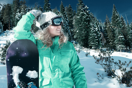 view of a young girl snowboarding in winter environmentの写真素材
