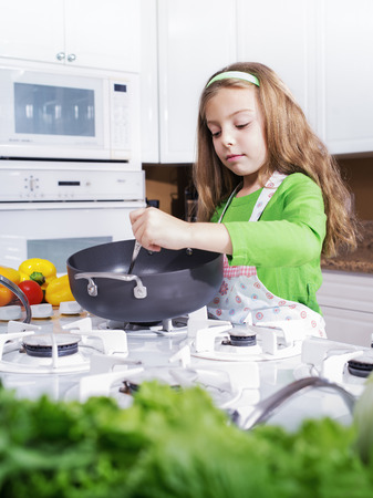 view of young beautiful girl cooking at the kitchenの写真素材