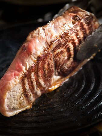 close up view on nice fresh steak is getting cookedの写真素材