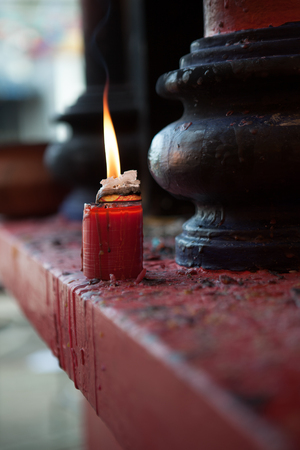close up view of red candle burning out in shrine environmentの写真素材