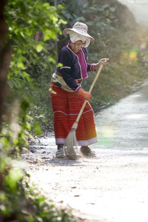 View of thai woman in authentic dress is cleaning streetの写真素材