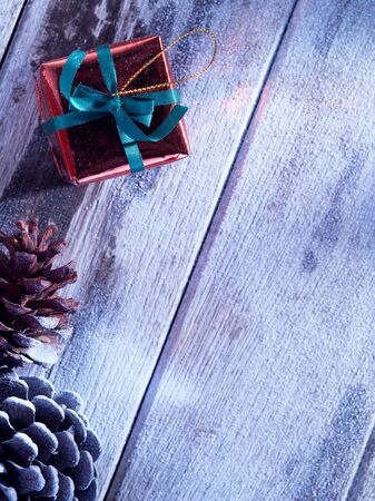 close up view  of cones and gift box on snowbound  wooden backの写真素材