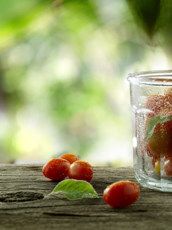 close up view of nice fresh cherry tomatoes on wooden tableの写真素材