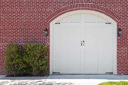 view of white wooden  garage doors and red bricks wallsの写真素材
