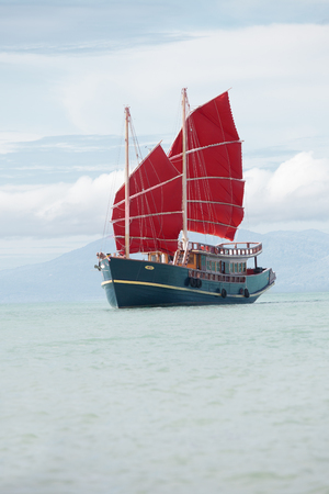 view of nice vintage look red sails spanish style boatの写真素材