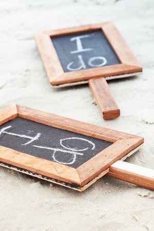 close up view of two i do wedding slots on sandy surfaceの写真素材