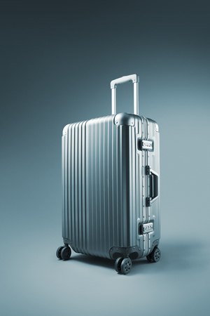 close up view of  nice metal  wheeled suitcase  on blue backgroundの写真素材