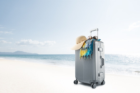 View of gray suitcase with pareo and hat on tropical  beachの写真素材