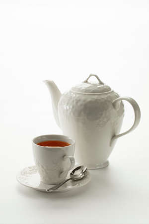 Close up view of china teapot and cup on white backgroundの写真素材