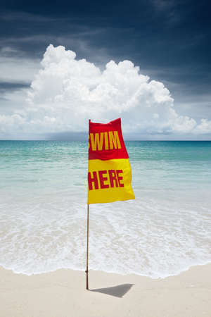 View of warning flag on nice warm tropic beach during law seasonの写真素材
