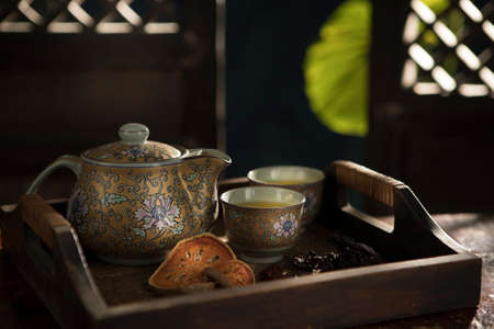 Close up view of nice china teapot and glasses on color backの写真素材