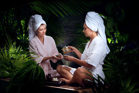 portrait of young beautiful women drinking tea  in spa environment.の写真素材