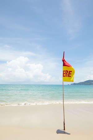 View of warning flag on nice warm tropic beach during law seasonの写真素材