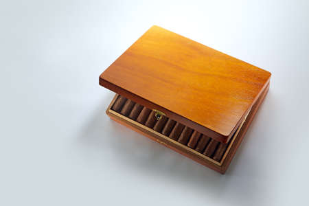 View of nice wooden humidor with cigars in it on white backの写真素材