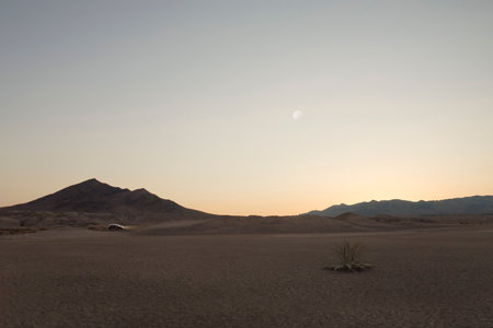 panoramic view death valley  desert with car and some mountains on the back during sunsetの写真素材